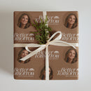 Gift box wrapped in brown paper featuring 'Better Tomorrow' design and a sprig of greenery on top with a white ribbon.