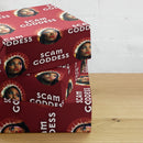 Wrapping paper featuring a woman with a halo, text reads 'SCAM GODDESS' on a red background.