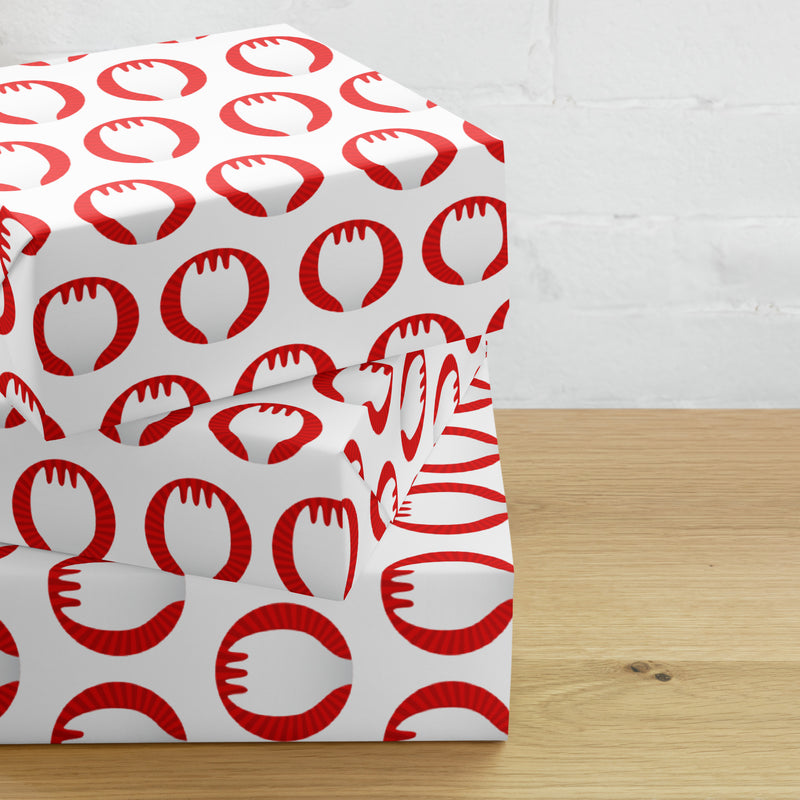 Stack of gift boxes wrapped in white paper with 'Sporkful" logo on a wooden surface.