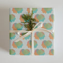 Colorful patterned wrapping paper featuring abstract shapes in pastel hues arranged in a repeating design.