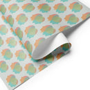 Colorful patterned wrapping paper featuring abstract shapes in pastel hues arranged in a repeating design.
