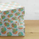 Stack of decorative gift boxes with a colorful floral pattern on a wooden surface.