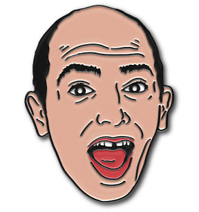Enamel pin of an illustrative face of Paul Scheer with wide open mouth, surprised expression, and short hair.