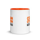 White mug with an orange interior. View opposite handle. 