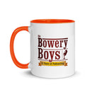 mug featuring the 'Bowery Boys' logo with a microphone and text celebrating 15 years of podcasting, orange handle and rim.