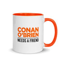 White mug with orange handle featuring the text 'Conan O'Brien needs a friend.'