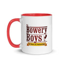Ceramic mug with red handle and interior featuring the 'Bowery Boys; logo and text celebrating 15 years of podcasting.